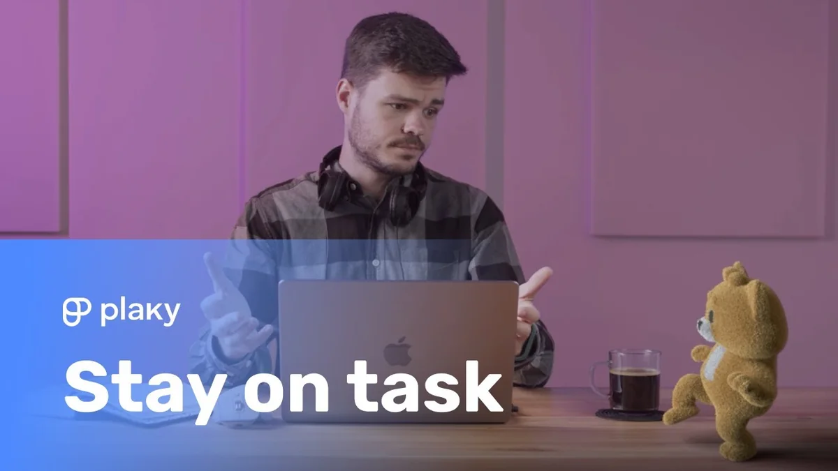 Plaky campaign thumbnail showing a man at a laptop looking toward a small knitted cat character, with the words Stay on task.